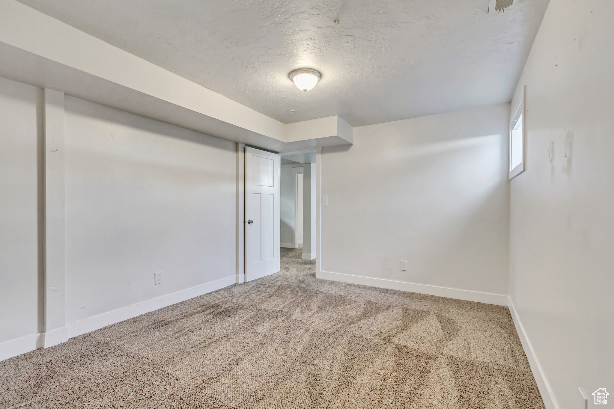 Basement with carpet flooring and a textured ceiling