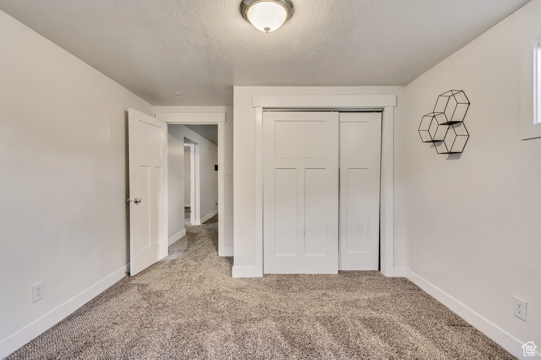 Unfurnished bedroom featuring light colored carpet and a closet