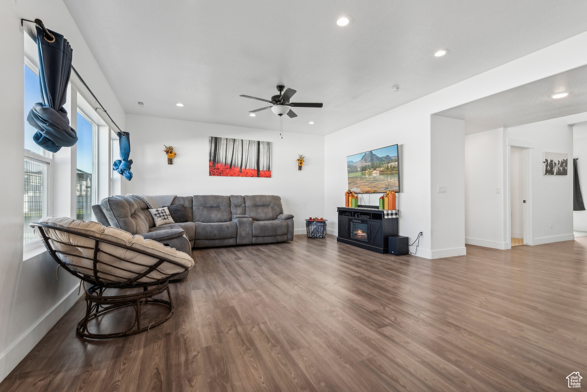 Living room featuring hardwood / wood-style flooring, ceiling fan, and a fireplace