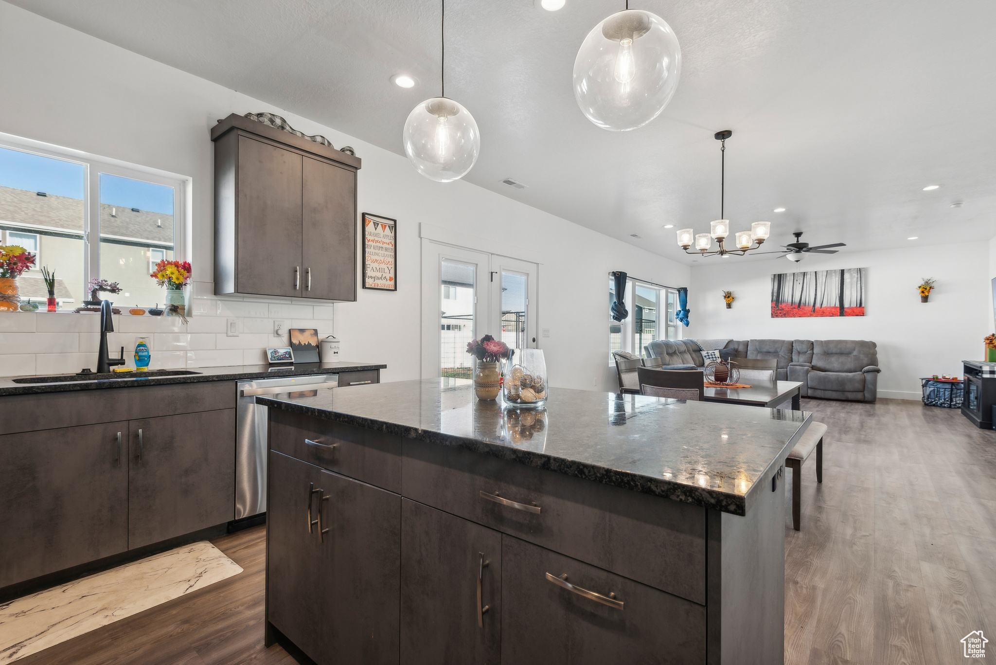 Kitchen featuring dark brown cabinets, dishwasher, pendant lighting, and a center island