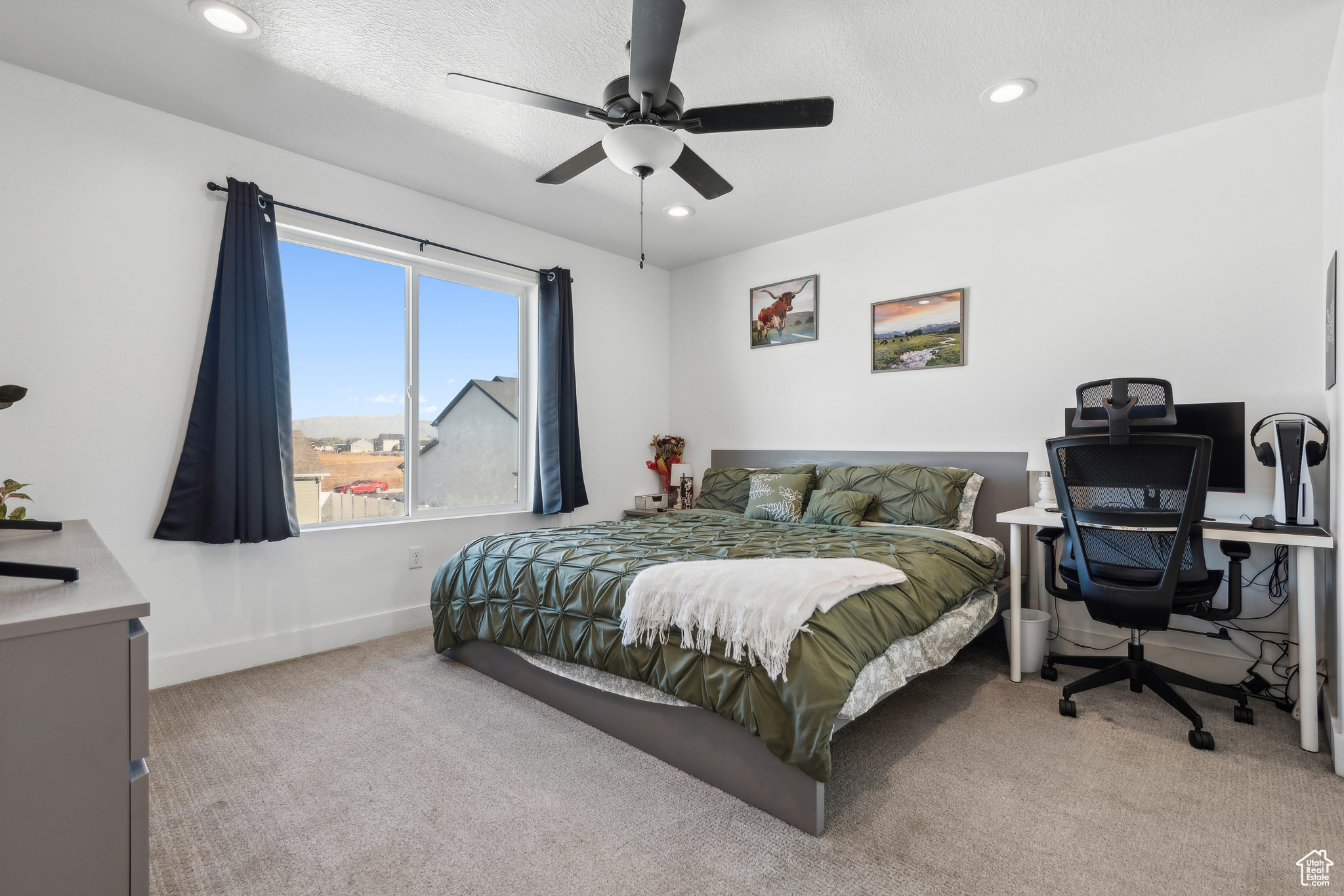 Carpeted bedroom with ceiling fan and a textured ceiling