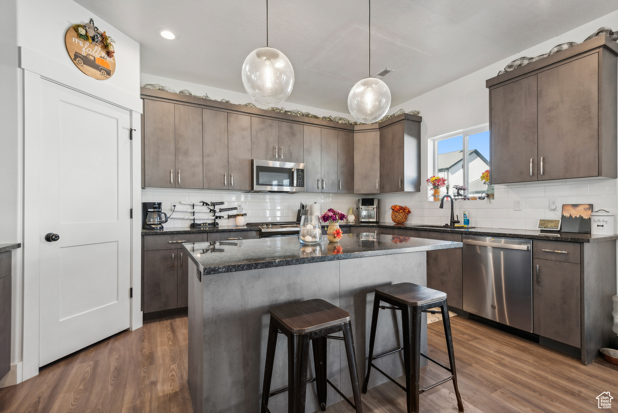 Kitchen featuring dark brown cabinetry, appliances with stainless steel finishes, and dark hardwood / wood-style flooring