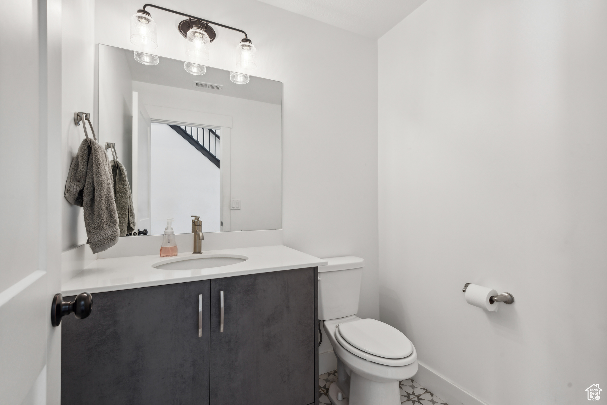 Bathroom featuring vanity, tile patterned floors, and toilet