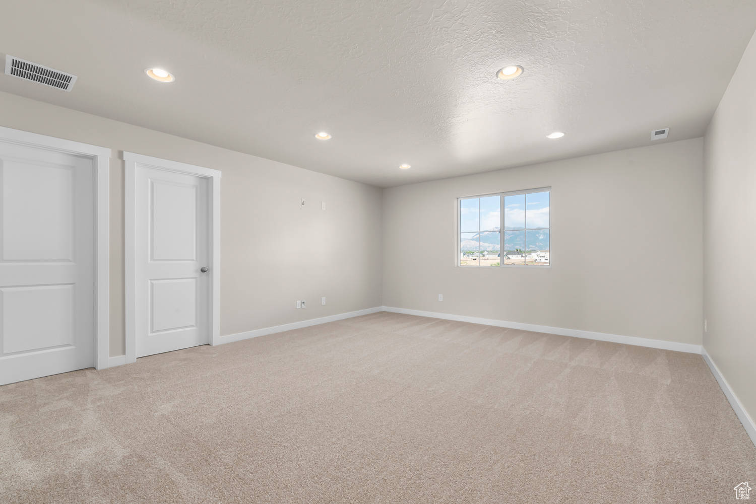 Carpeted empty room featuring a textured ceiling