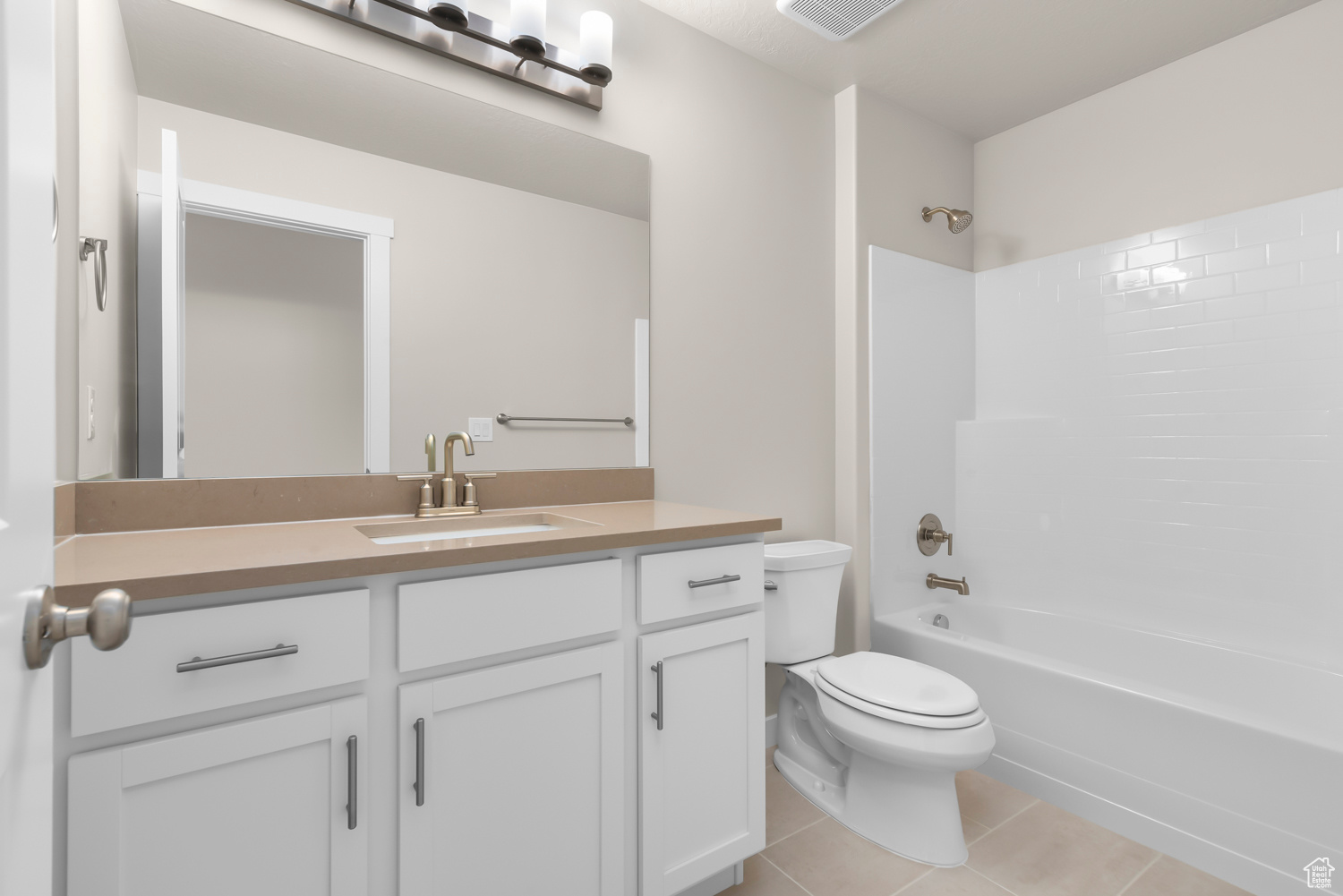 Full bathroom with toilet, vanity, tile patterned flooring, and shower / washtub combination