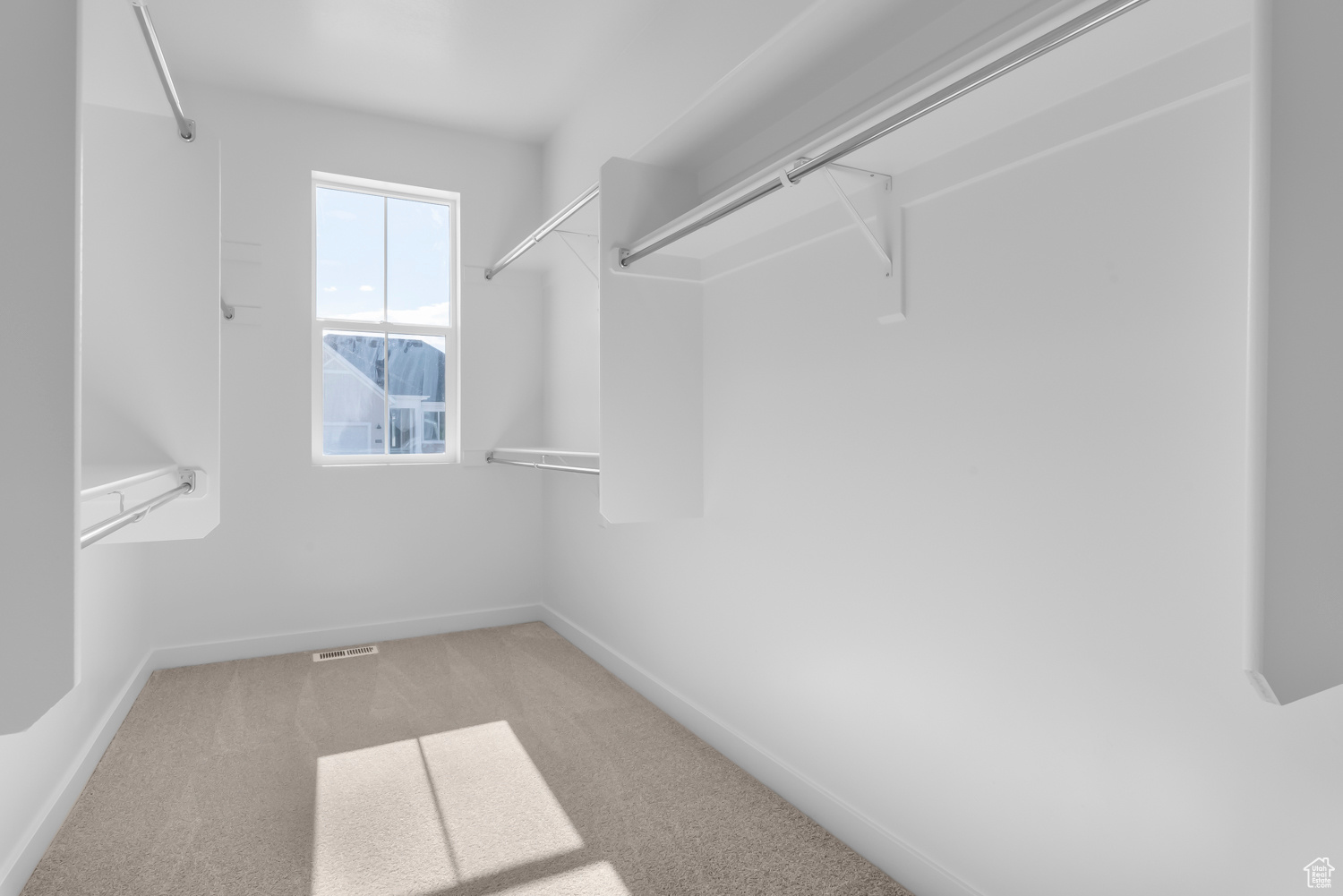 Walk in closet featuring light carpet