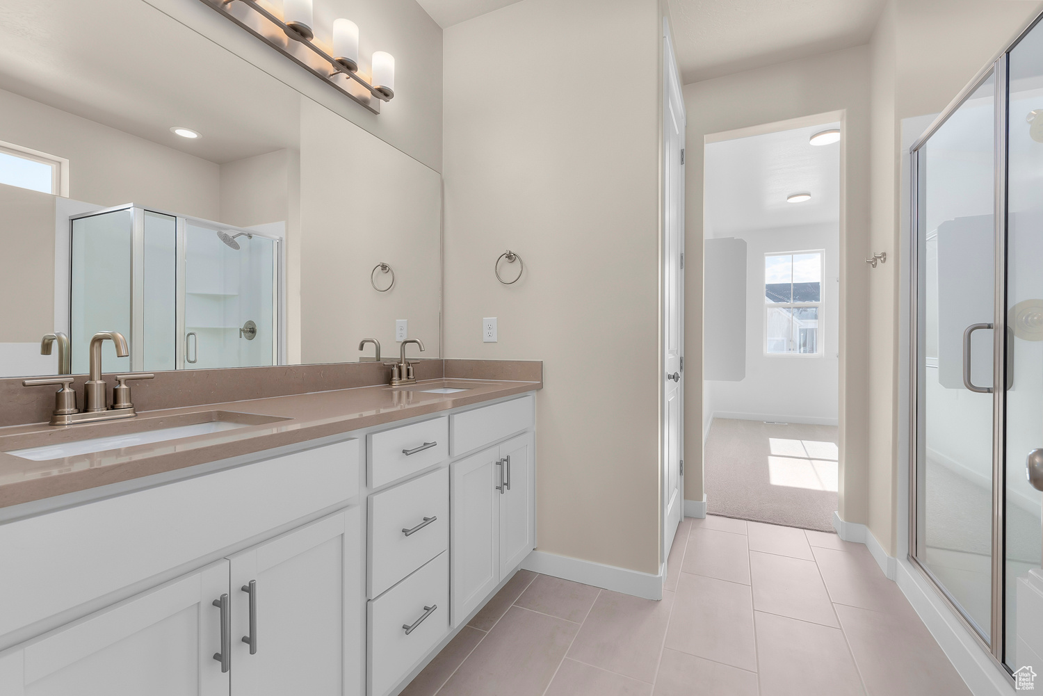 Bathroom featuring walk in shower, vanity, and tile patterned flooring