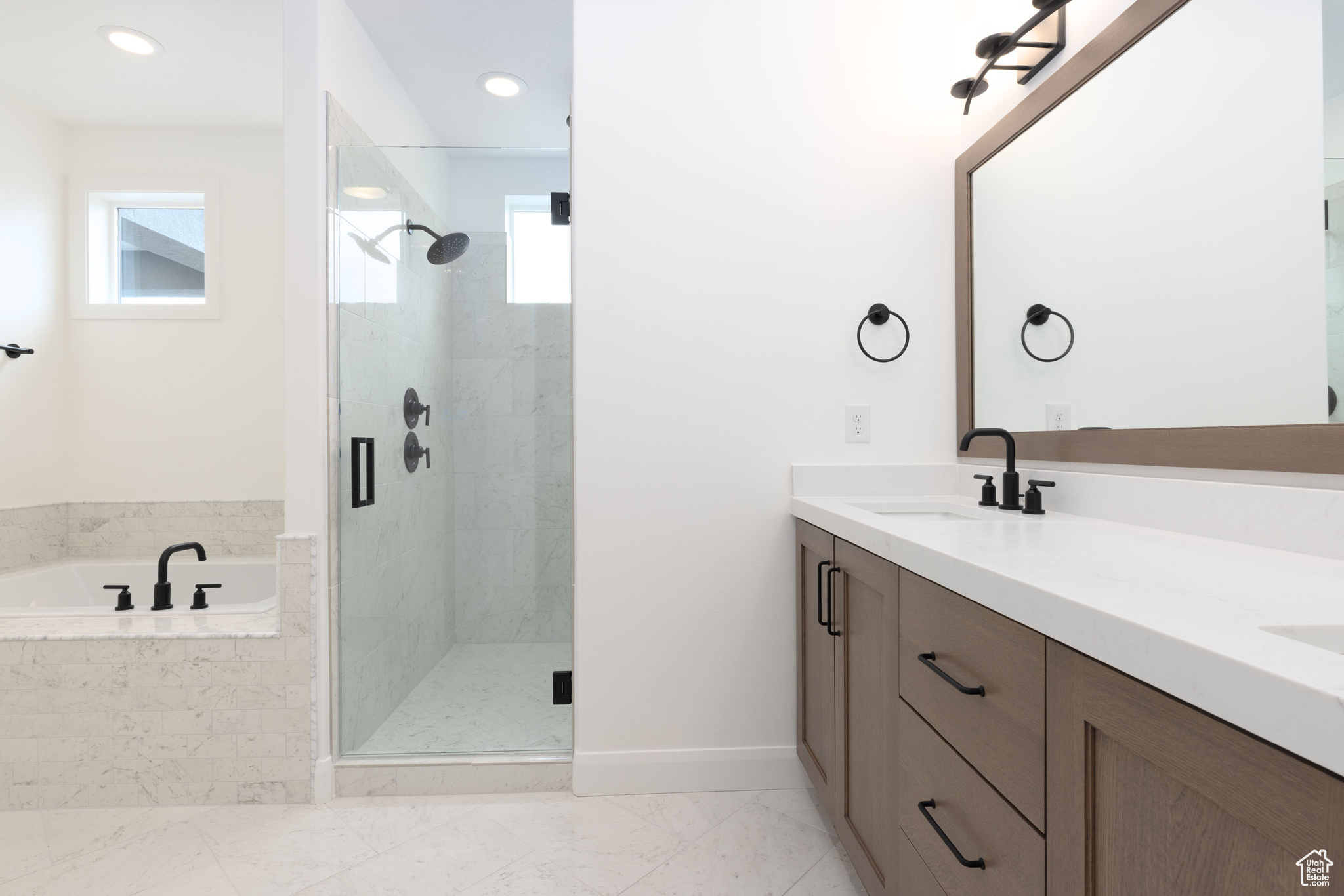 Bathroom featuring vanity and separate shower and tub