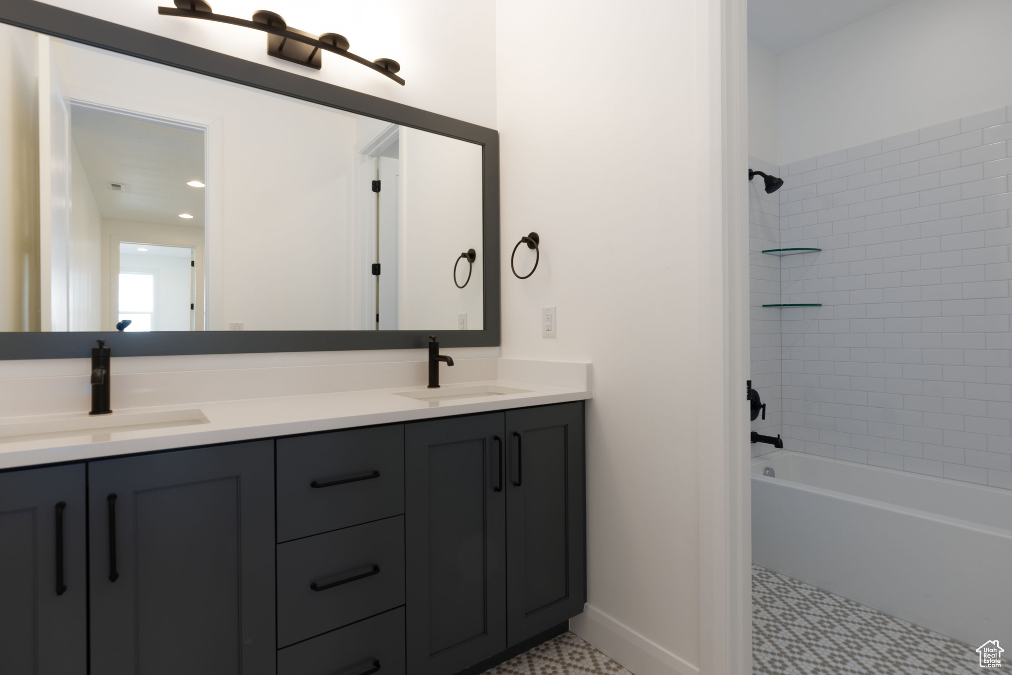 Bathroom with tiled shower / bath combo and vanity