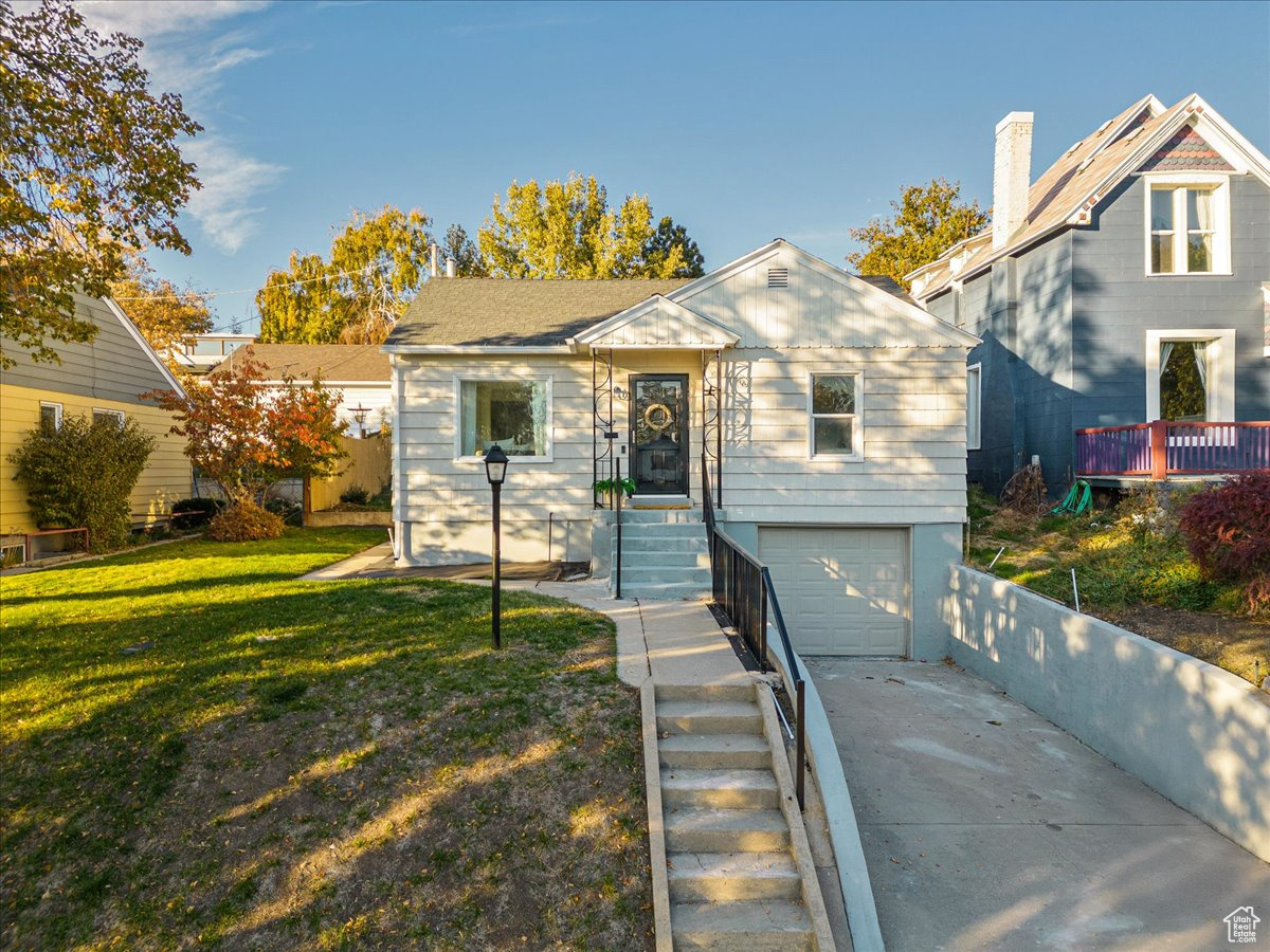 View of front of home with a garage and a front yard