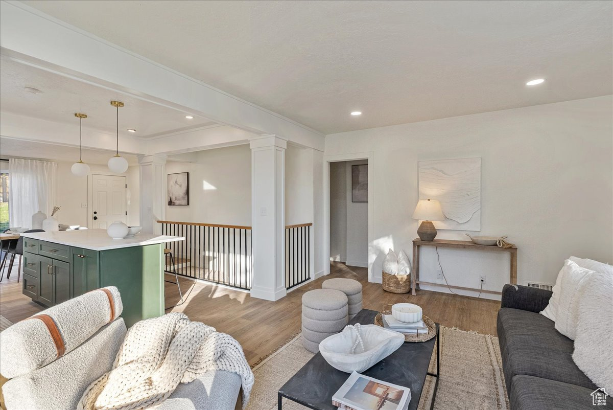 Living room featuring light wood-type flooring and decorative columns