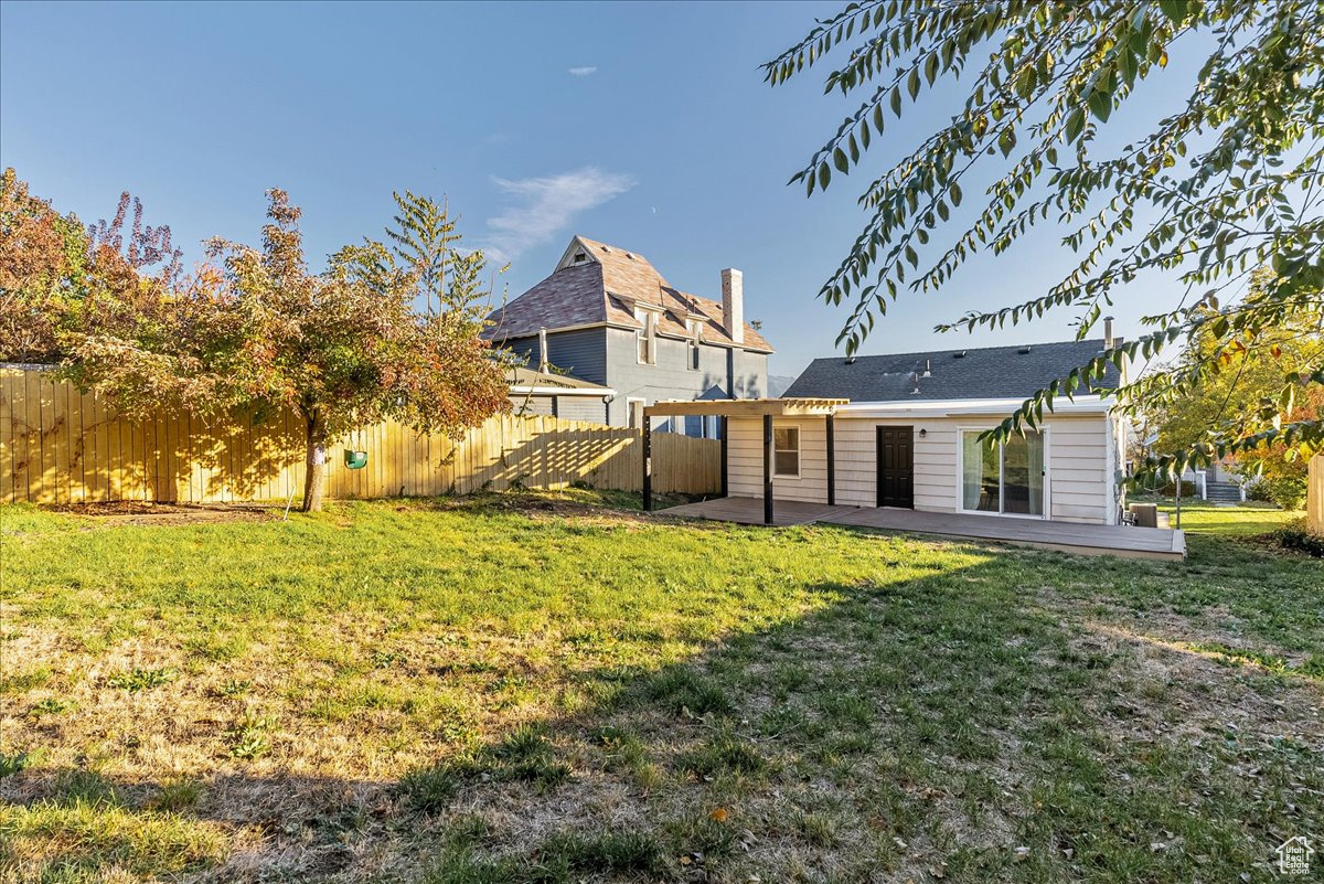 Back of house with a patio and a yard