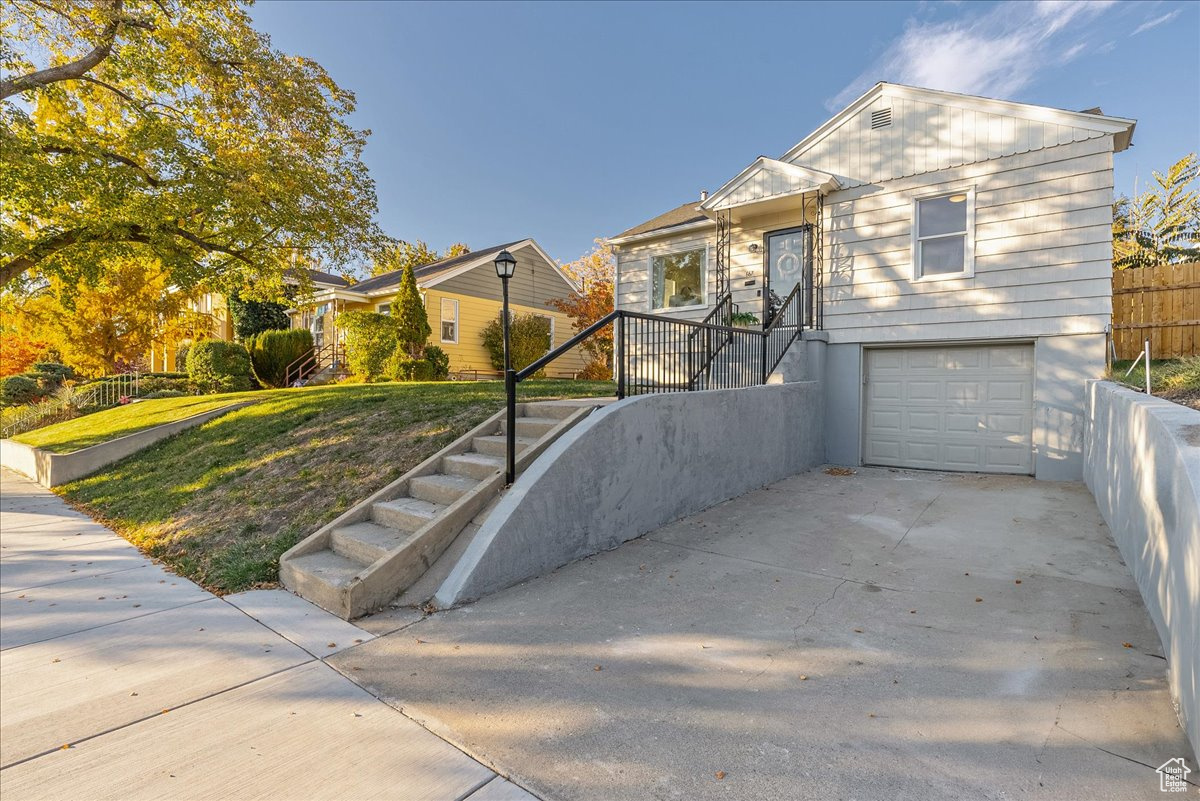 View of front of house featuring a garage and a front lawn