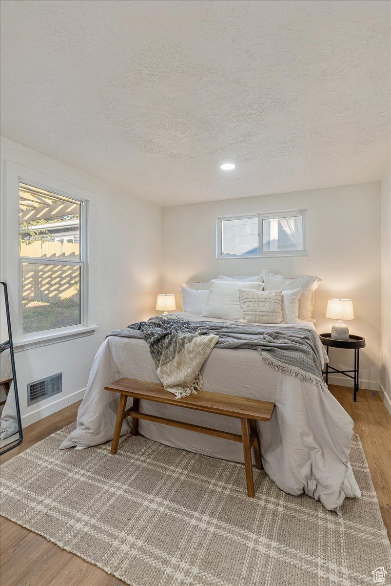 Bedroom featuring wood-type flooring and a textured ceiling