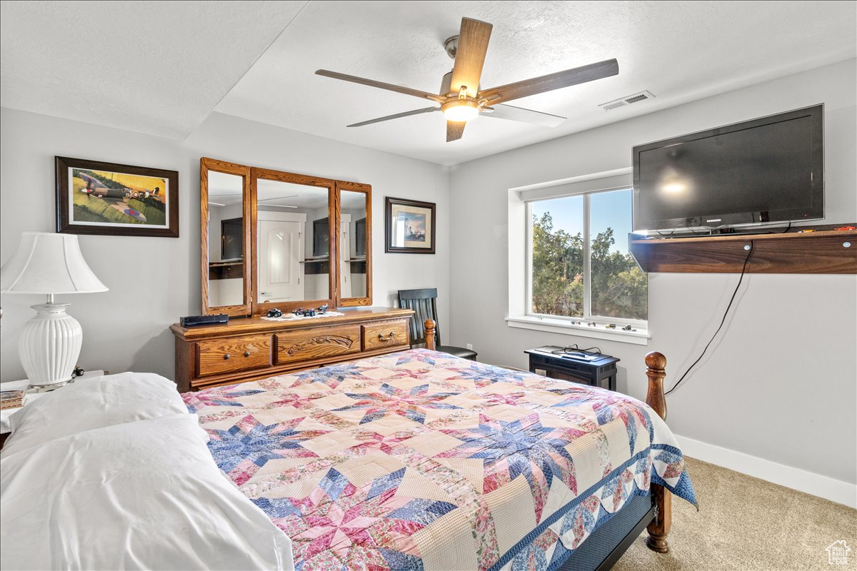 Downstairs Bedroom with carpet, ceiling fan and Mountain View