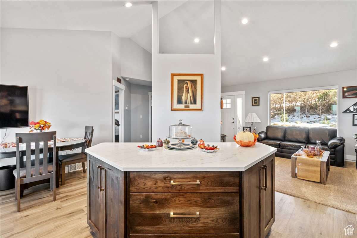 Kitchen and living room featuring cathedral ceilings and light quartz countertop