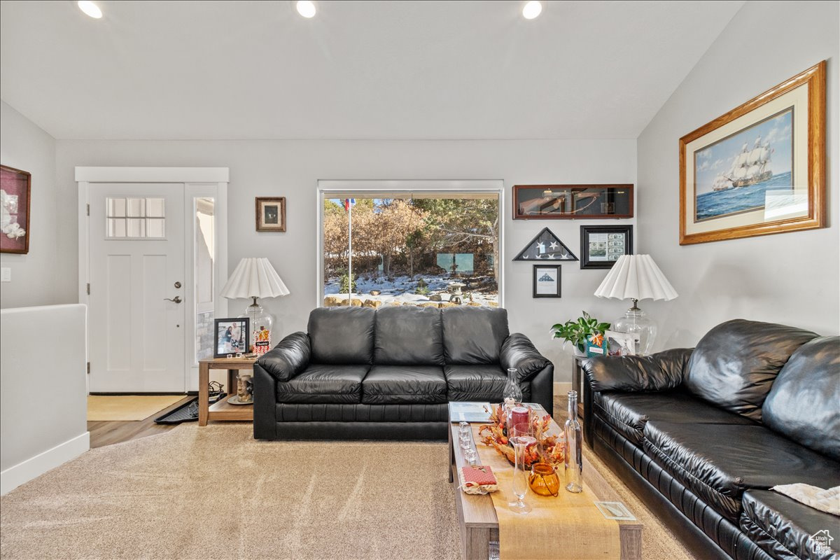 Living room featuring cathedral ceiling with carpet