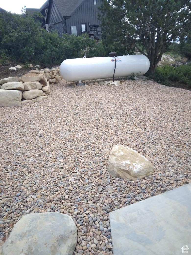 South side of home featuring rock work and 1000 gallon propane tank