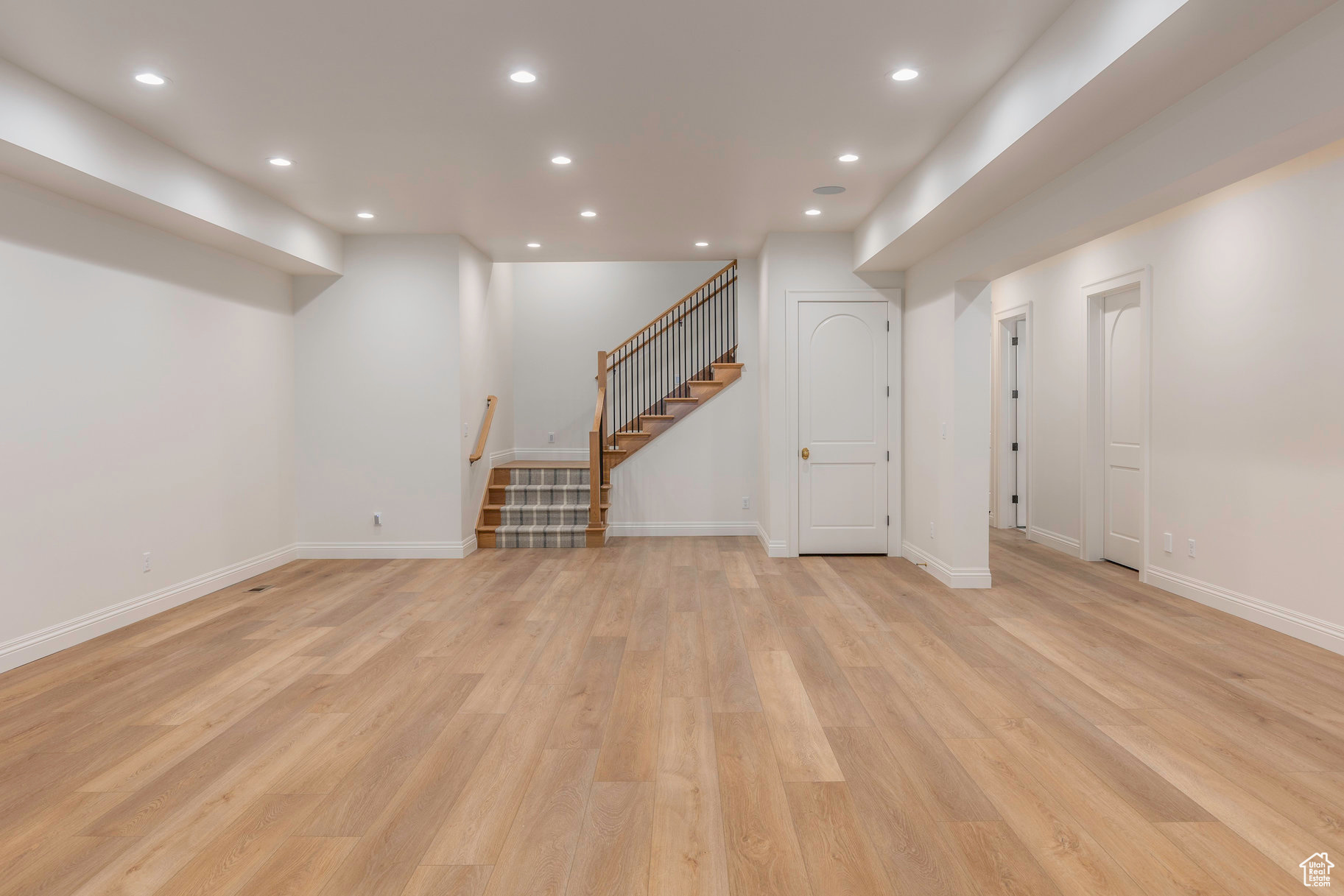 Basement with light hardwood / wood-style flooring