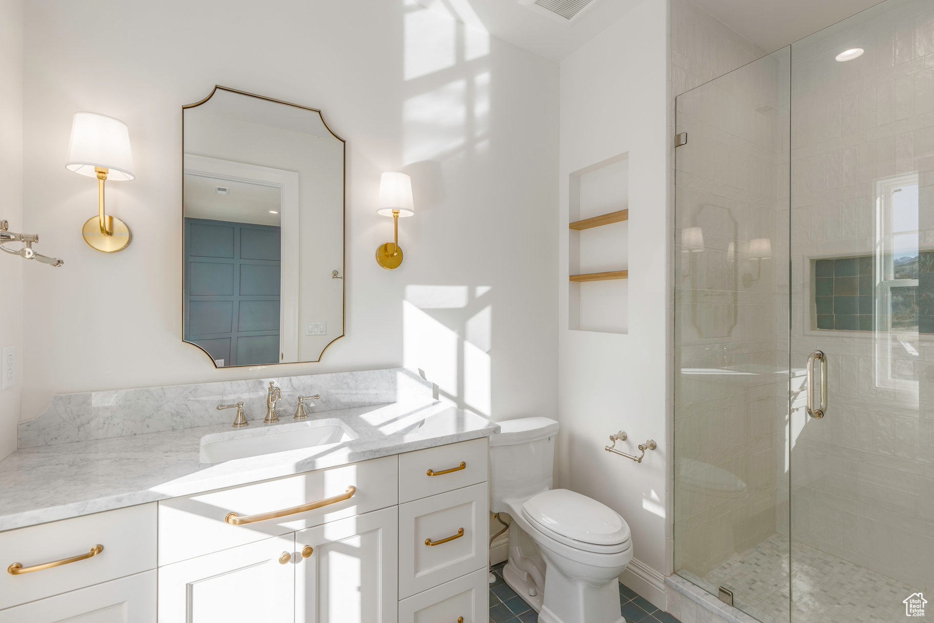 Bathroom with tile patterned floors, vanity, toilet, and an enclosed shower