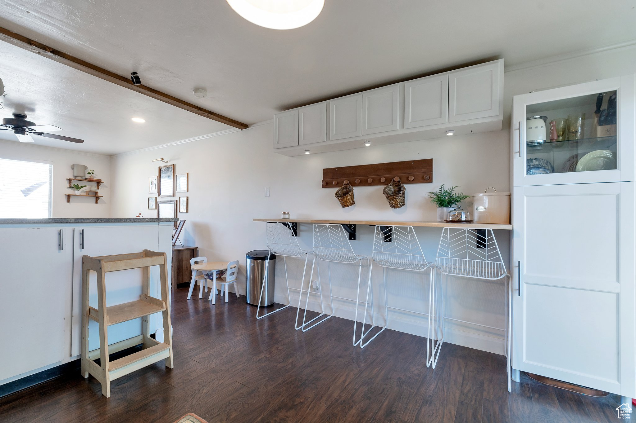 Kitchen with white cabinetry, a kitchen breakfast bar, dark hardwood / wood-style floors, and ceiling fan