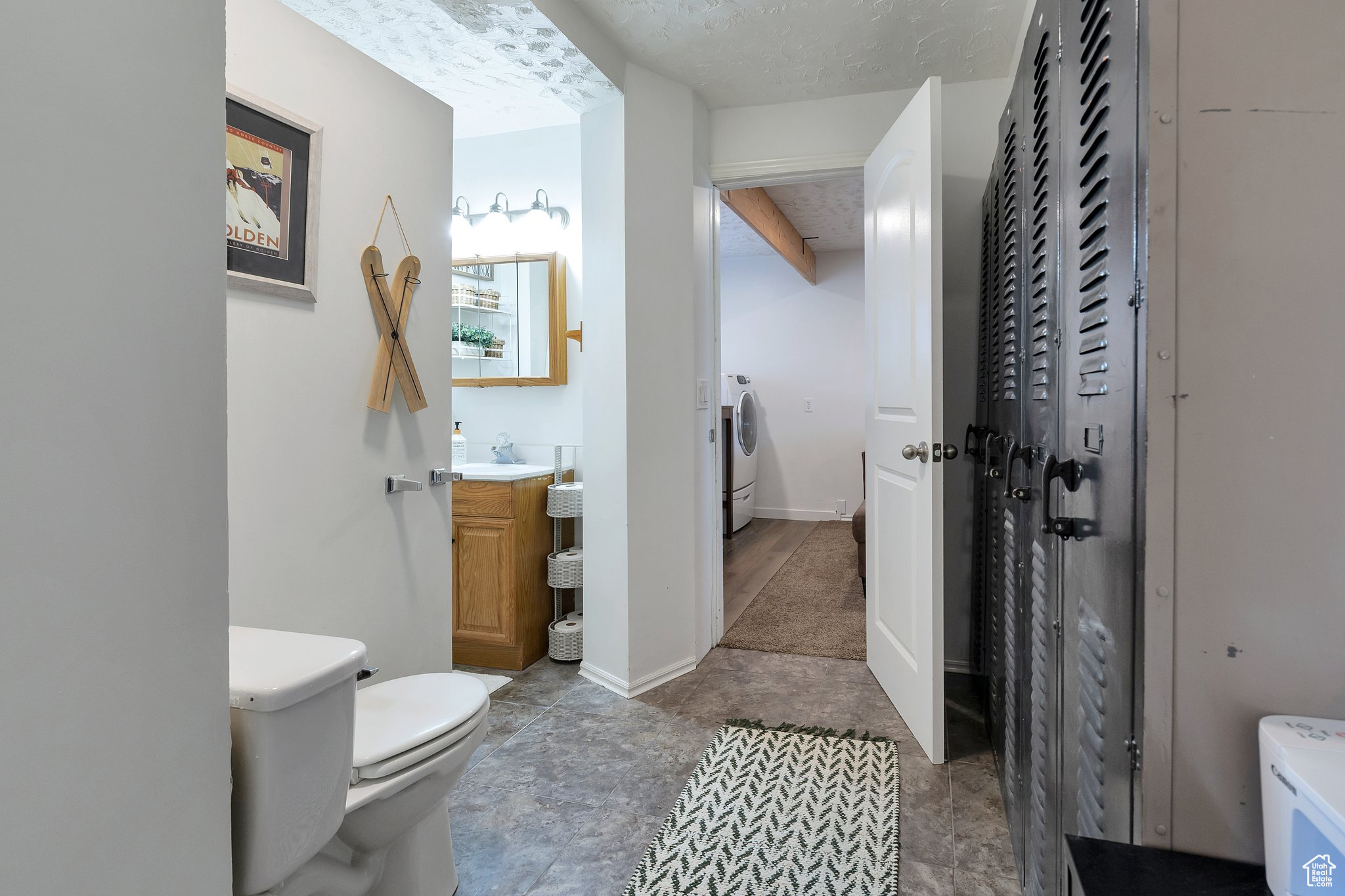 Bathroom featuring toilet, washing machine and dryer, and vanity