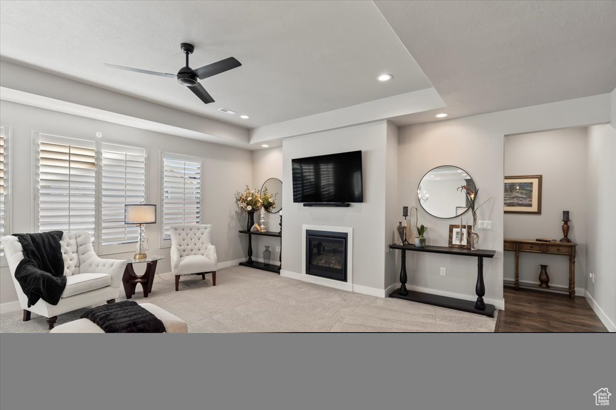 Living room featuring ceiling fan and light carpet