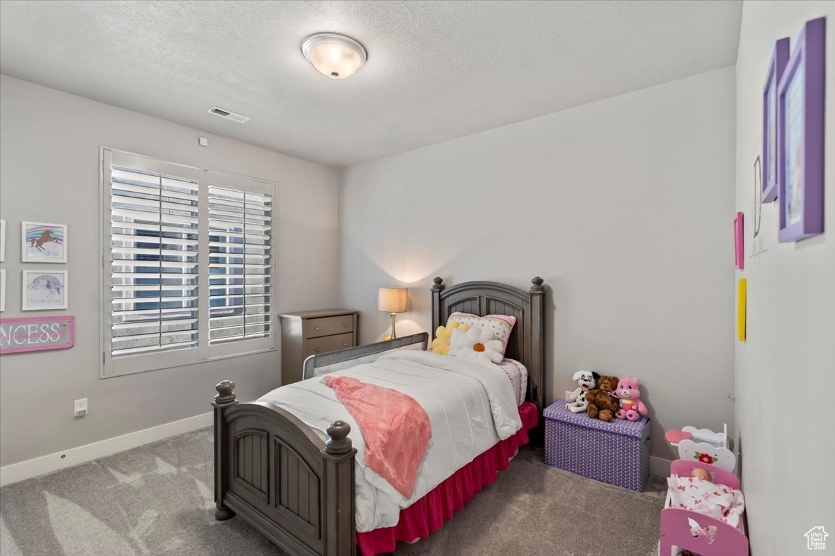 Carpeted bedroom featuring a textured ceiling