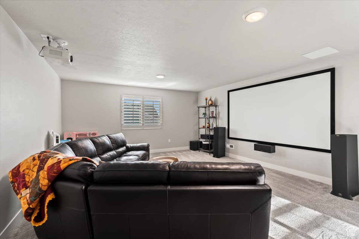 Carpeted cinema room featuring a textured ceiling