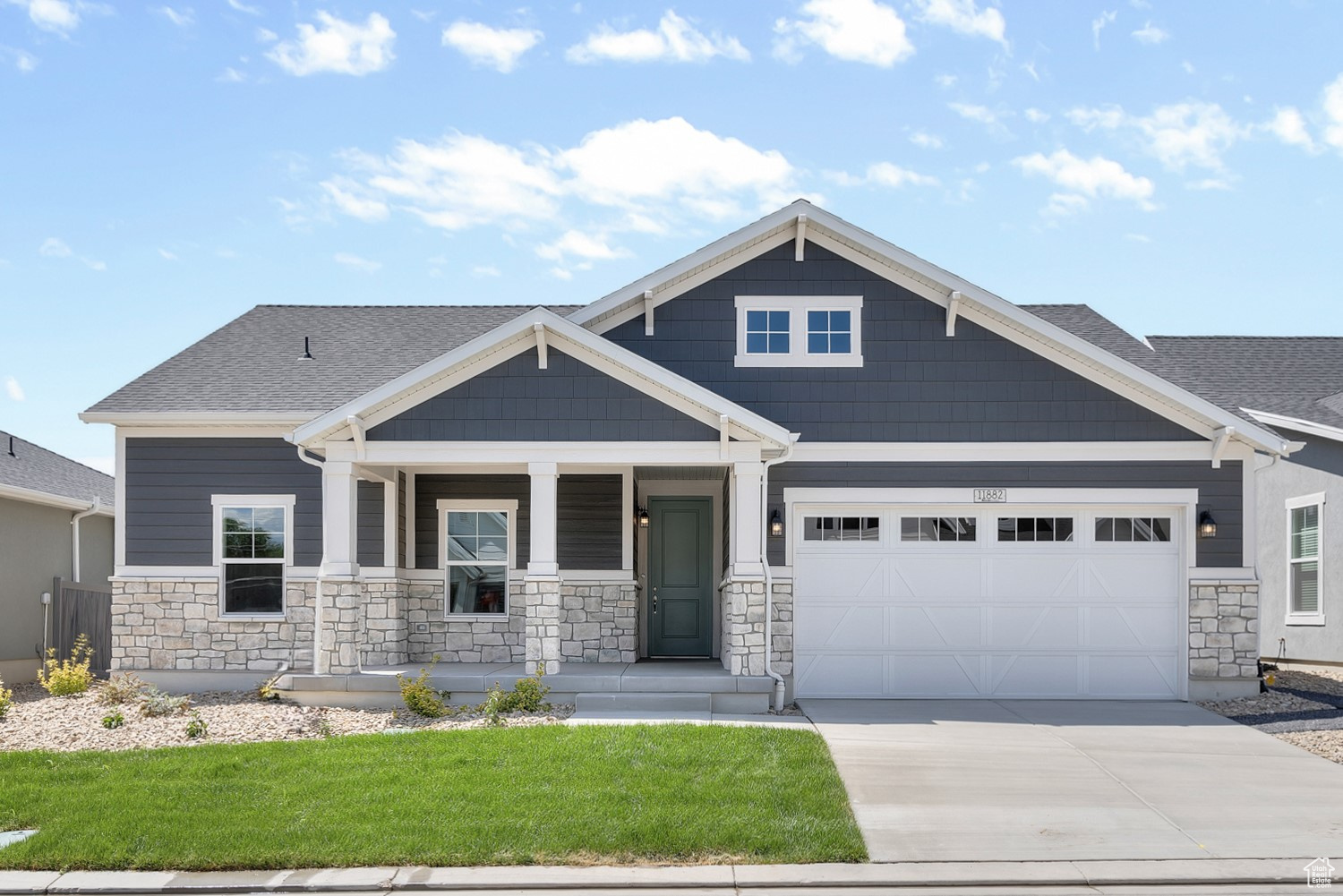 Craftsman-style home featuring a garage, covered porch, and a front lawn