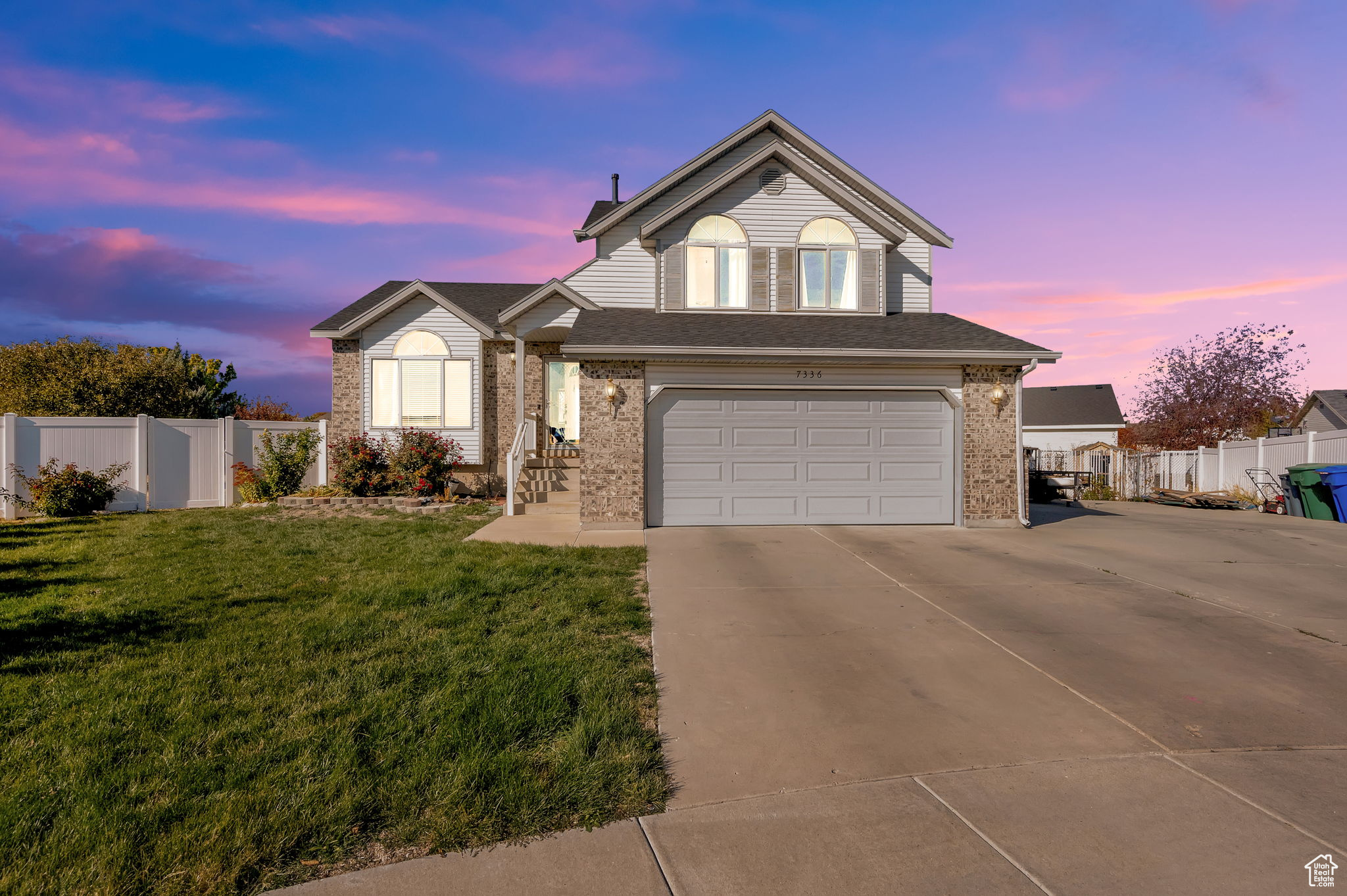 View of front of home with a garage and a yard