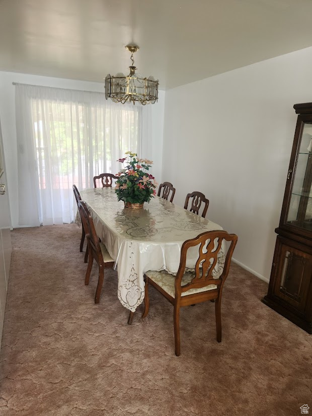 Dining space with carpet flooring and a notable chandelier