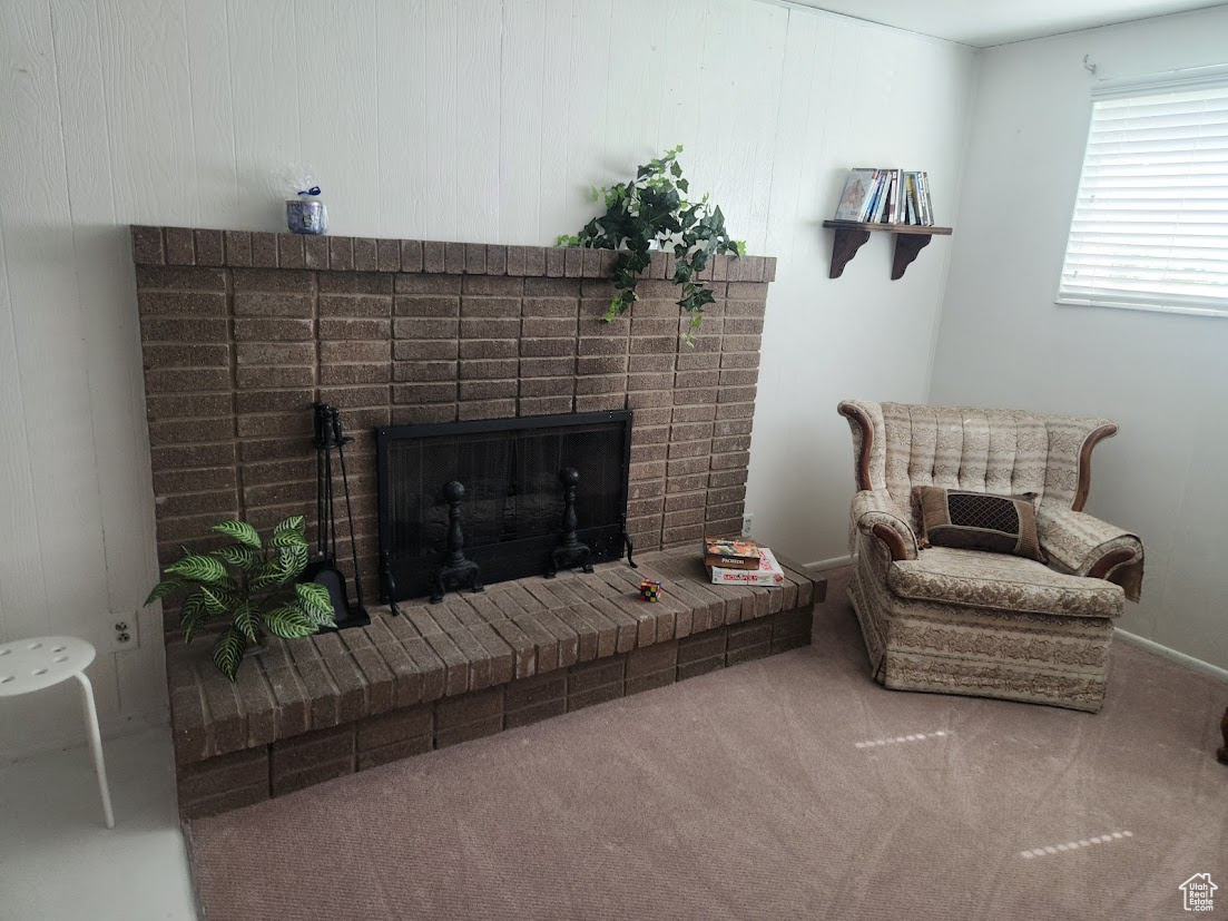 Living room featuring carpet floors and a brick fireplace