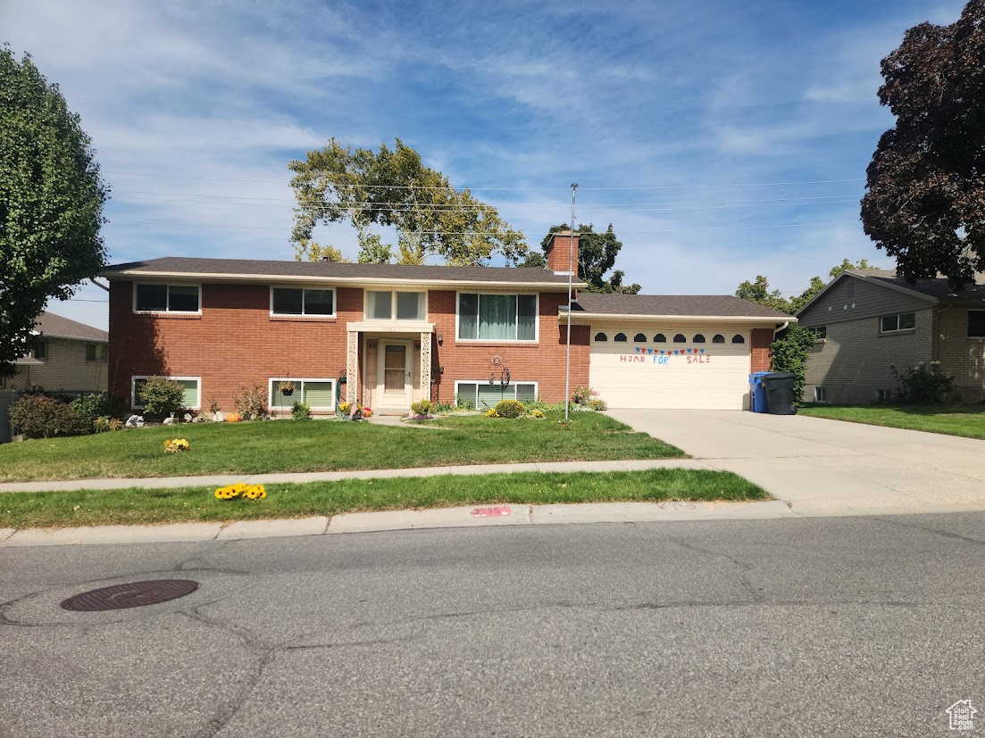 View of front of home with a garage and a front yard