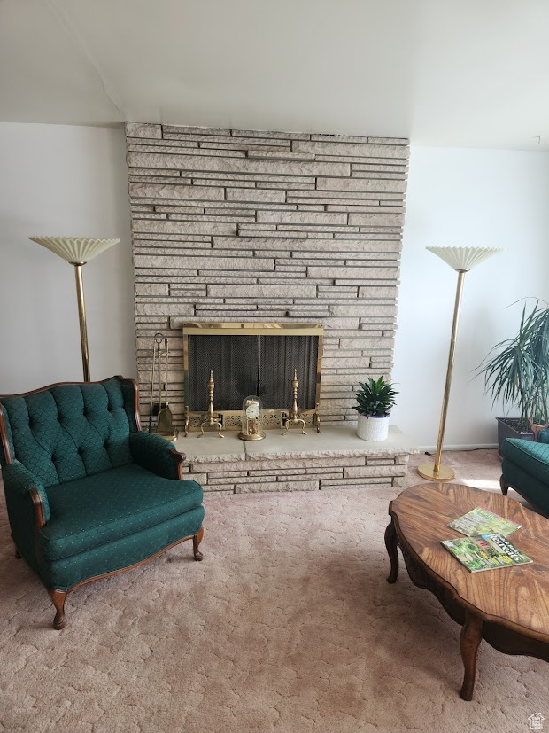 Living area with a fireplace and carpet