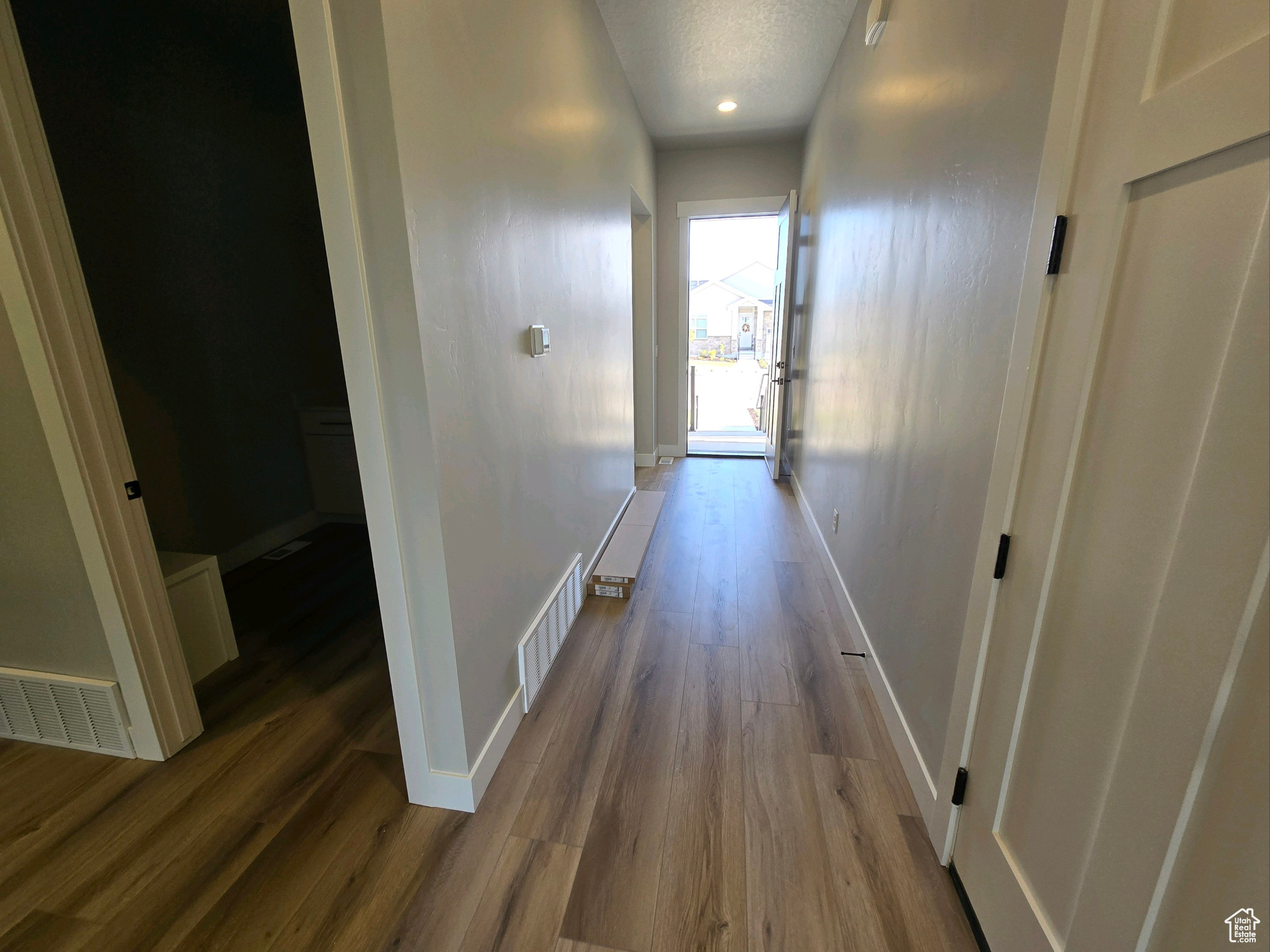 Hall featuring hardwood / wood-style floors and a textured ceiling