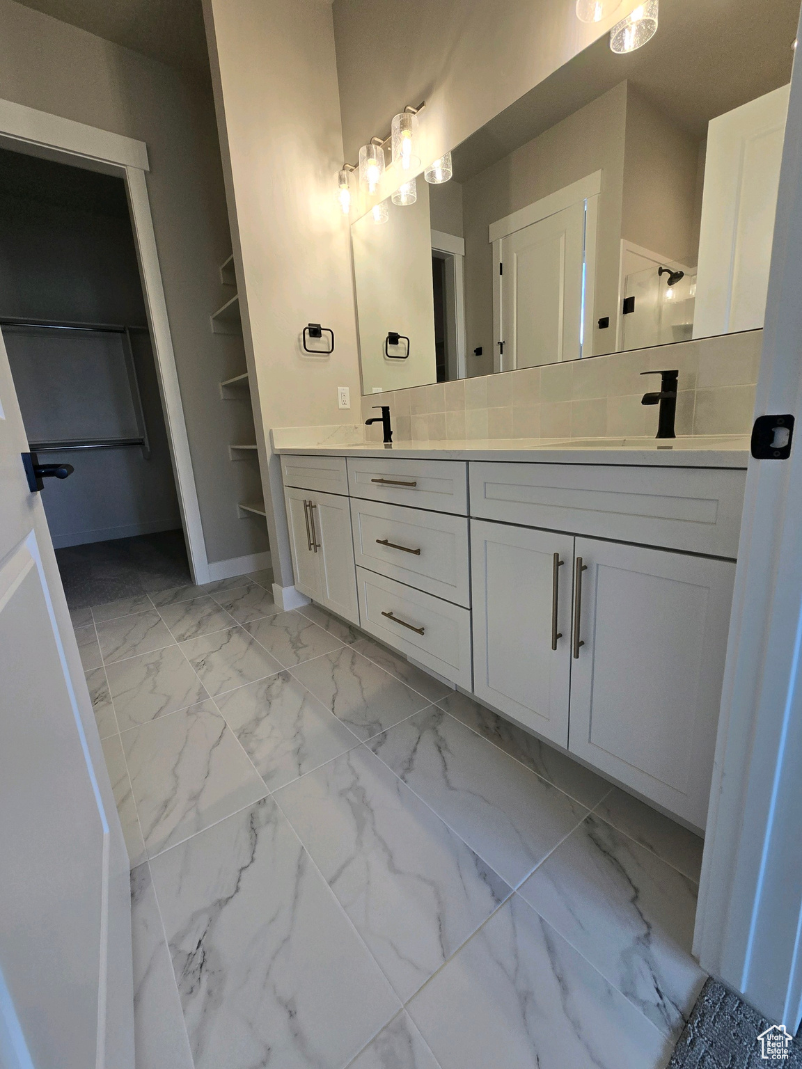 Bathroom featuring decorative backsplash and vanity