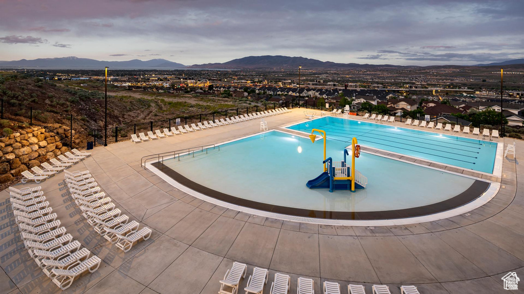 View of swimming pool with a patio and a mountain view