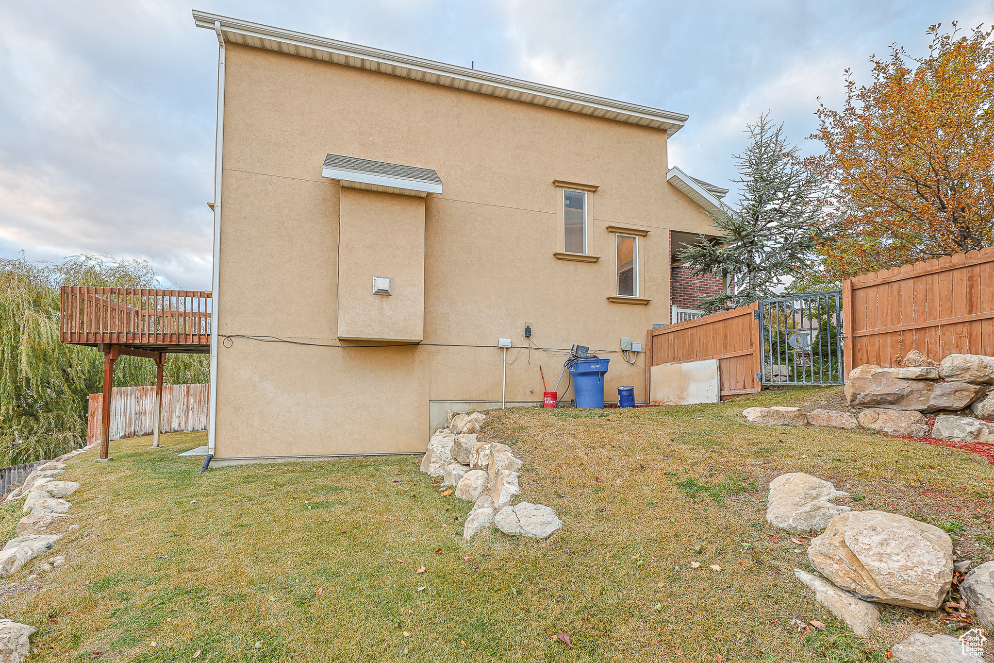 Rear view of property with a wooden deck and a lawn