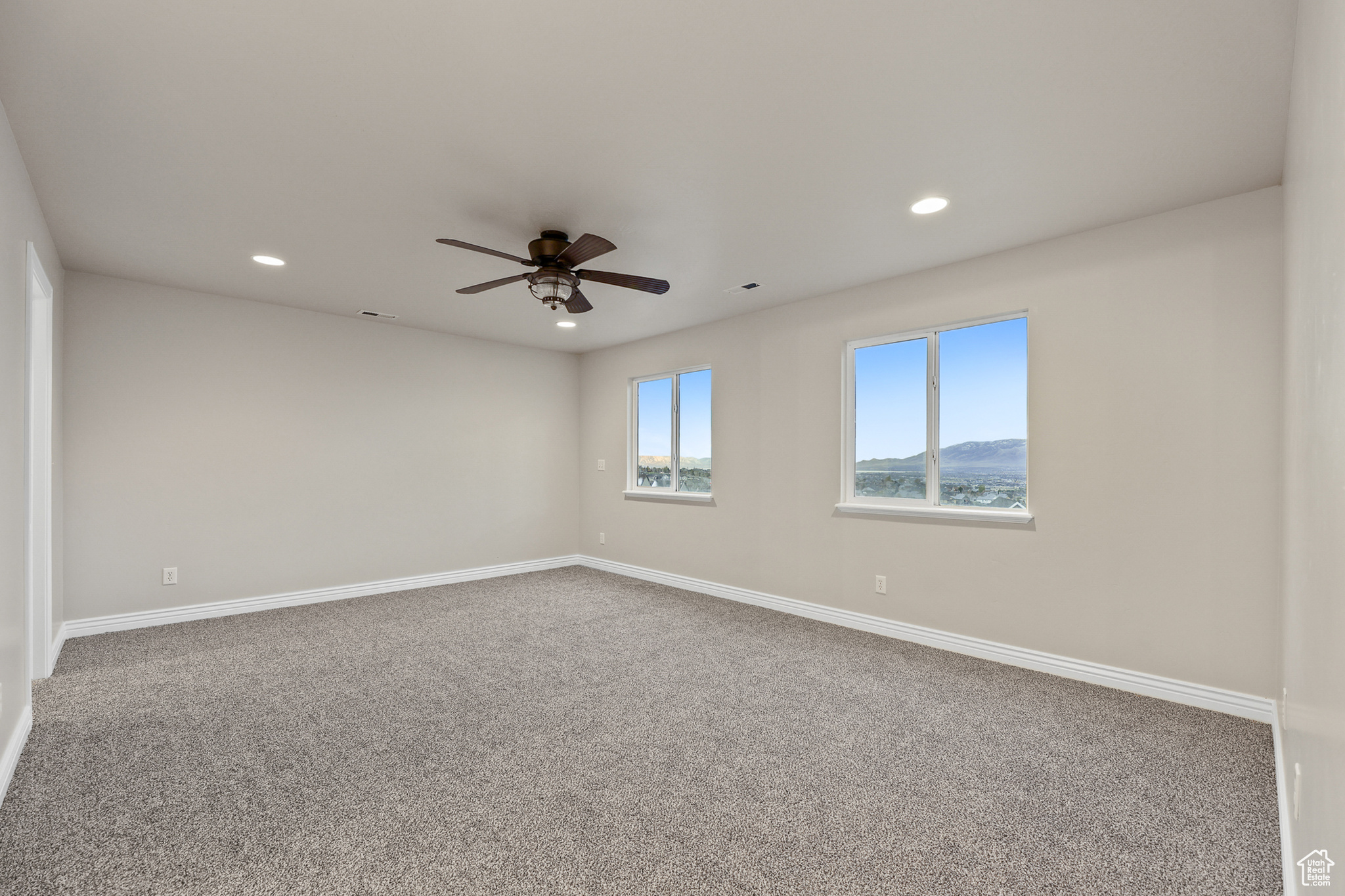 Primary suite room with carpet and ceiling fan