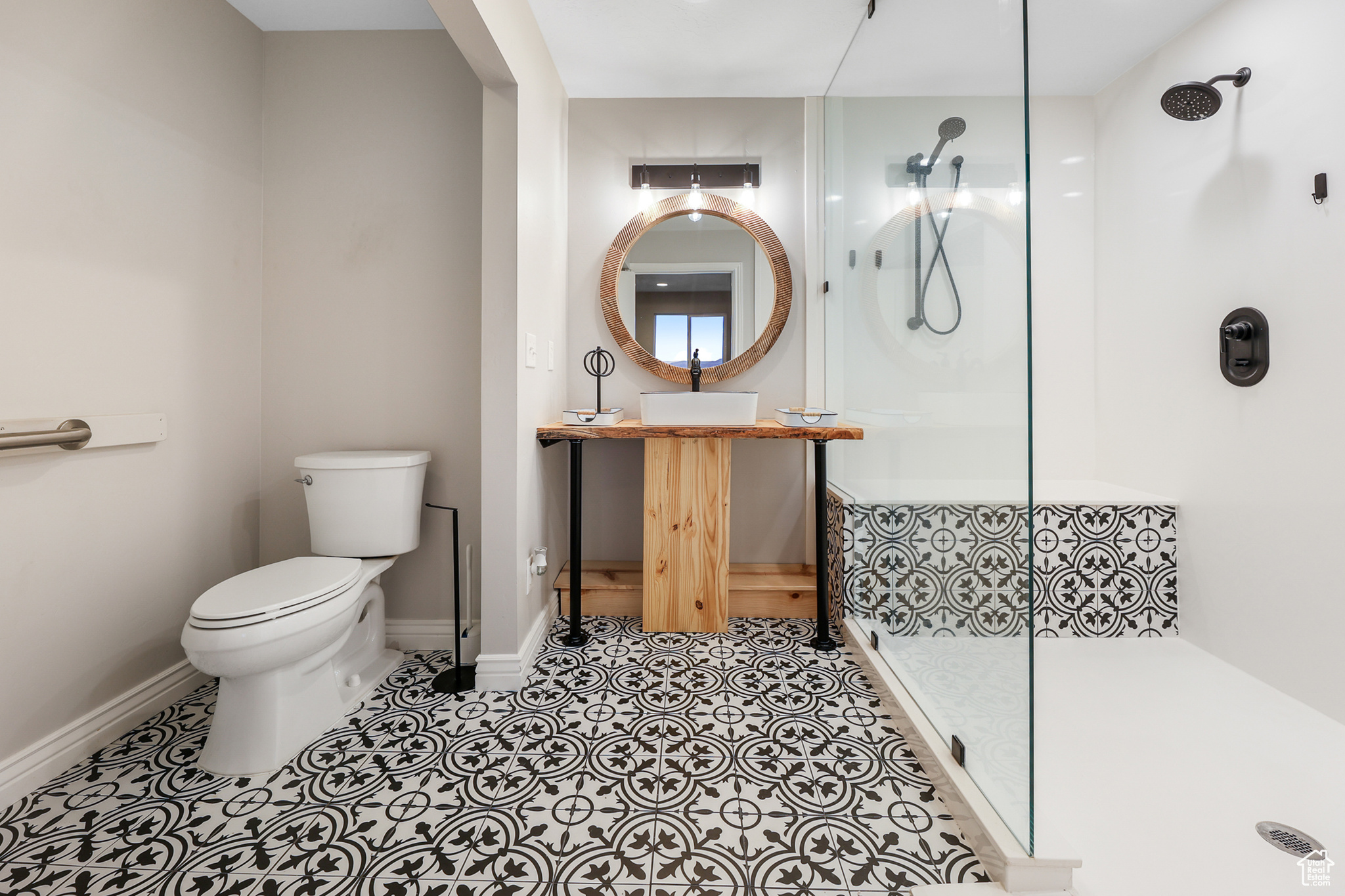 Ensuite bathroom featuring vanity, walk in shower, tile patterned flooring, and toilet