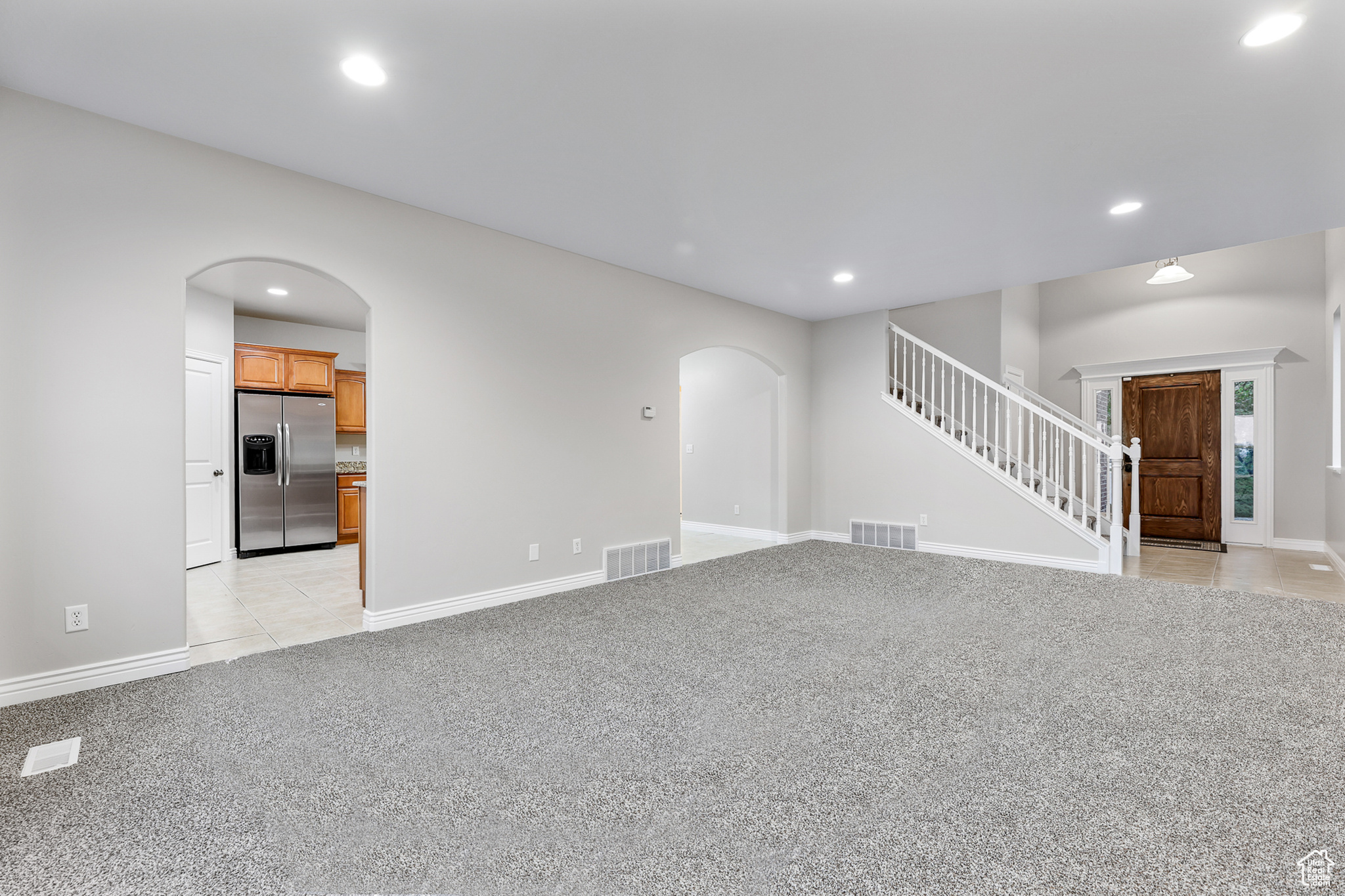 Unfurnished living room featuring light carpet