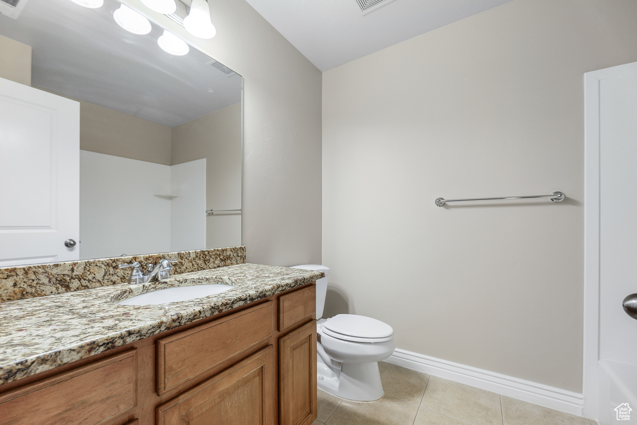 Bathroom featuring vanity, tile patterned floors, and toilet