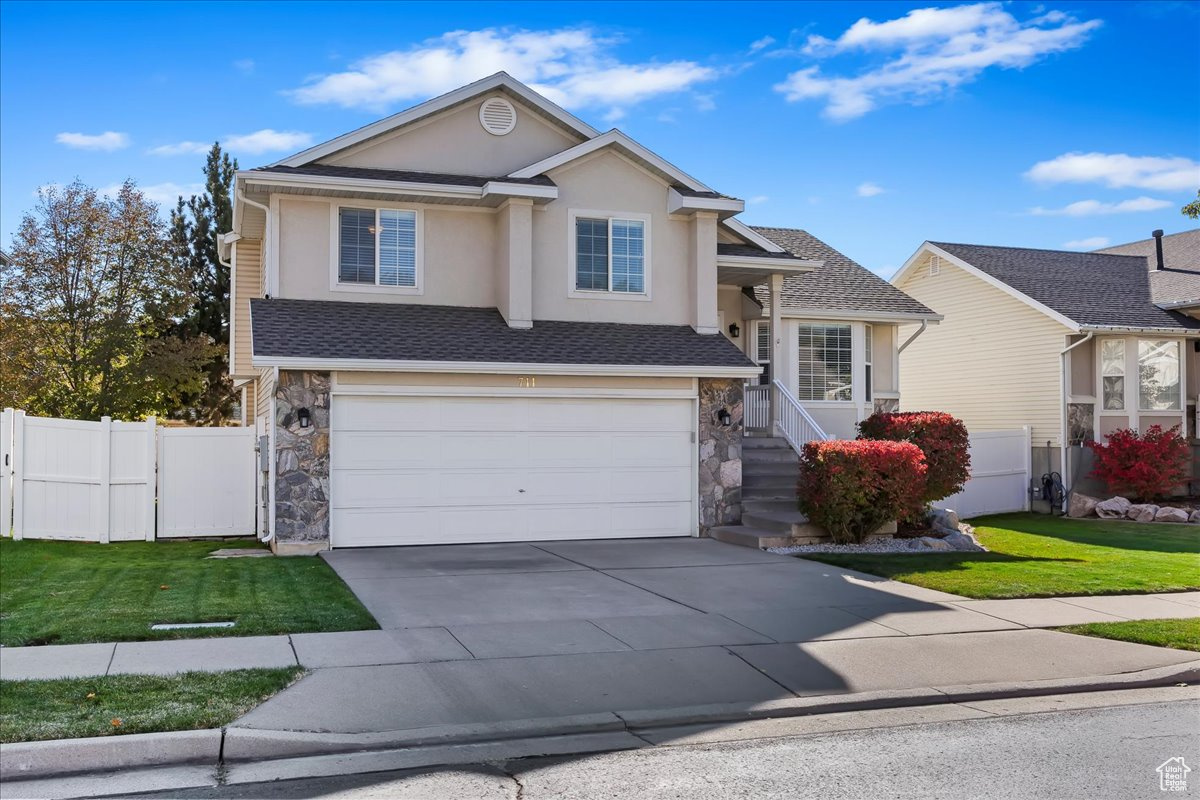 View of front of house featuring a garage and a front yard