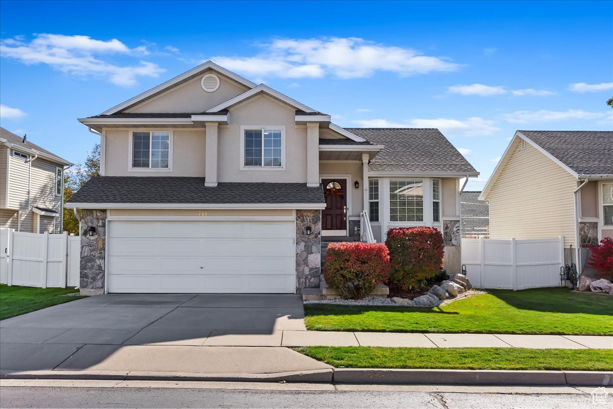 View of front of property featuring a garage and a front yard