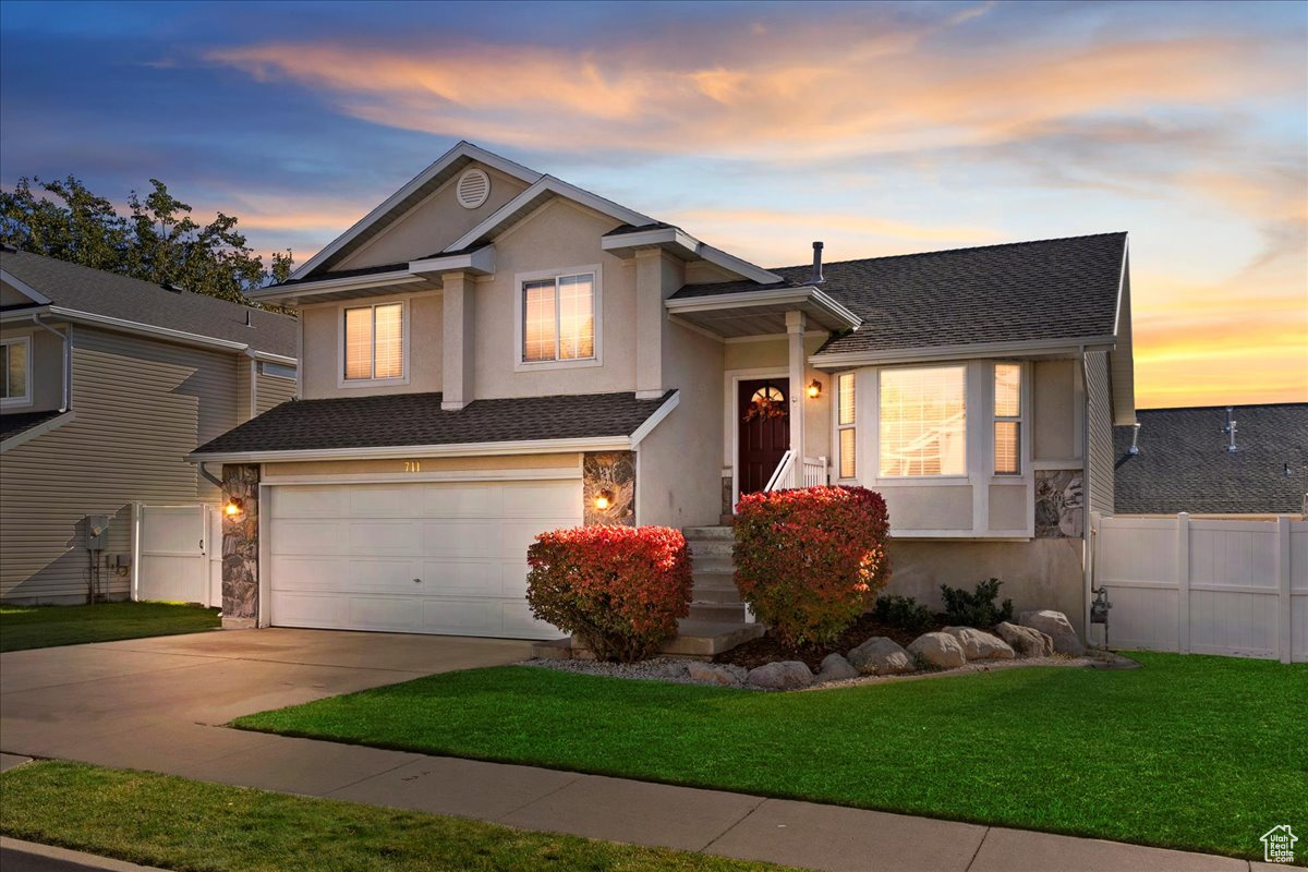 Tri-level home with a garage and a yard