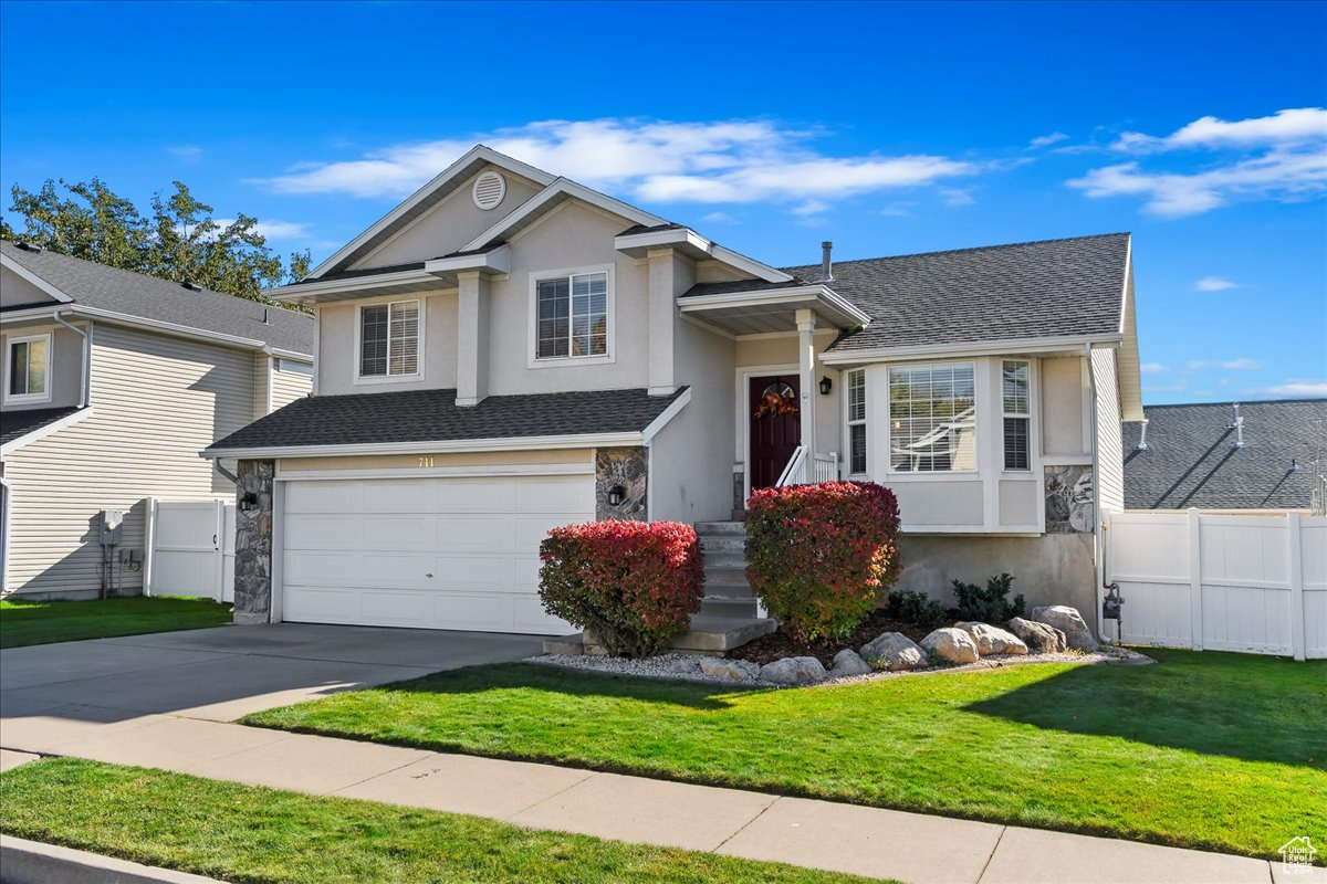 View of front of home with a garage and a front yard