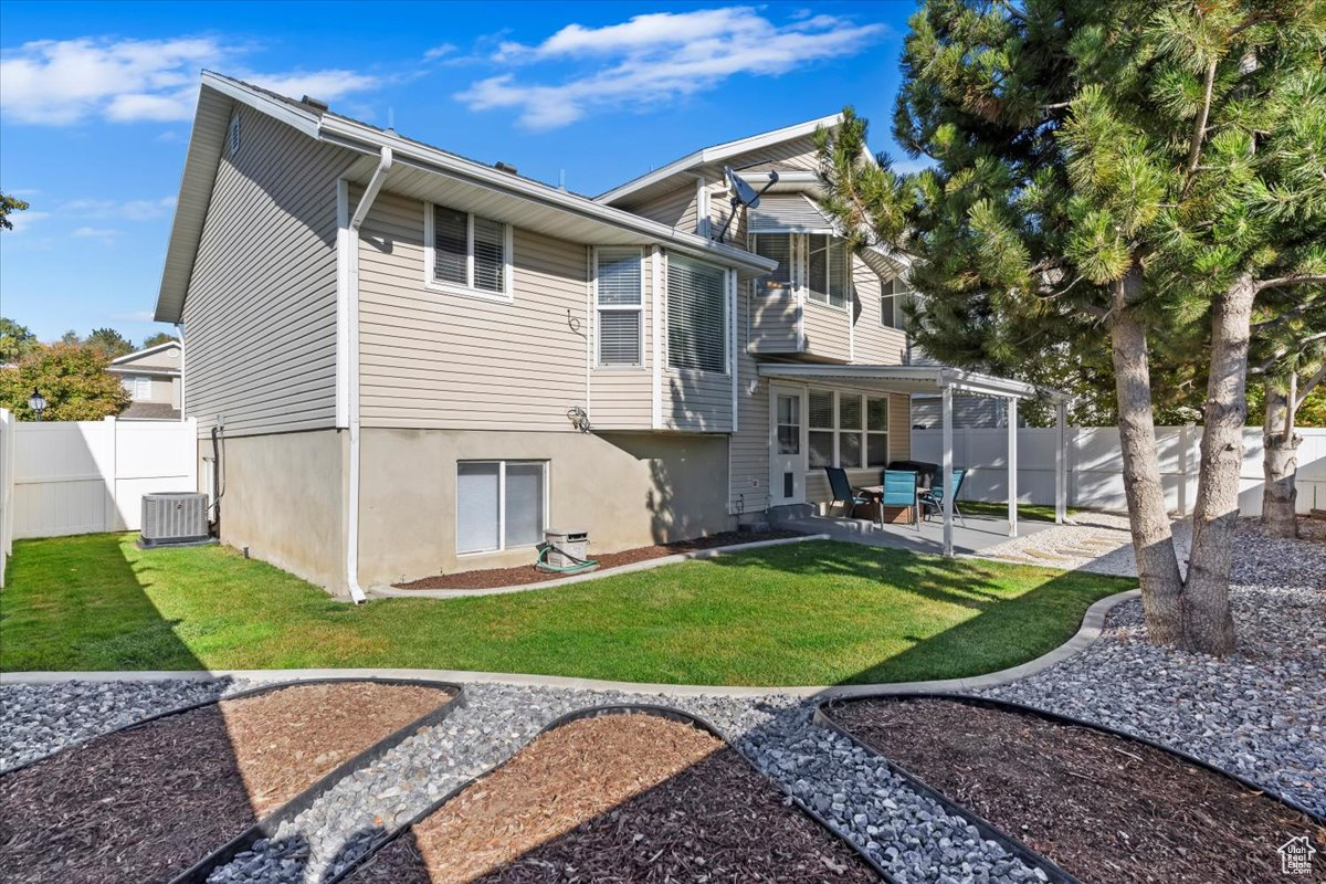 Back of property with a yard and a patio area