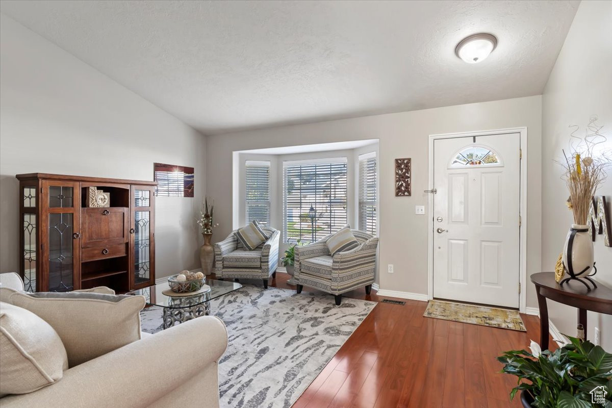 Living room featuring hardwood / wood-style floors and lofted ceiling