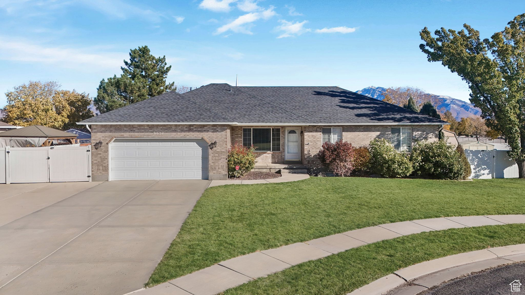 Ranch-style home featuring a garage, a front lawn, and a mountain view